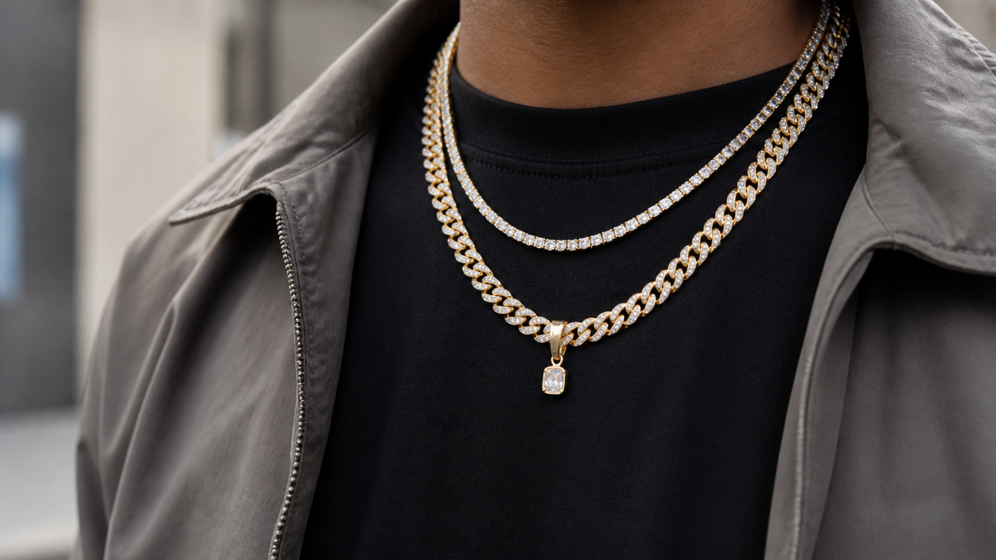 Layered iced tennis chain and Cuban link chain worn over a black shirt