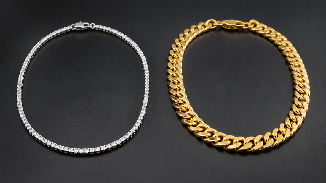 Silver tennis chain beside a gold Cuban link chain on a dark studio surface